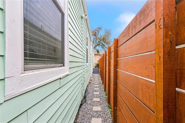 view of side of home featuring fence