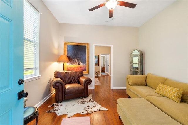 living room with baseboards, a ceiling fan, and wood finished floors