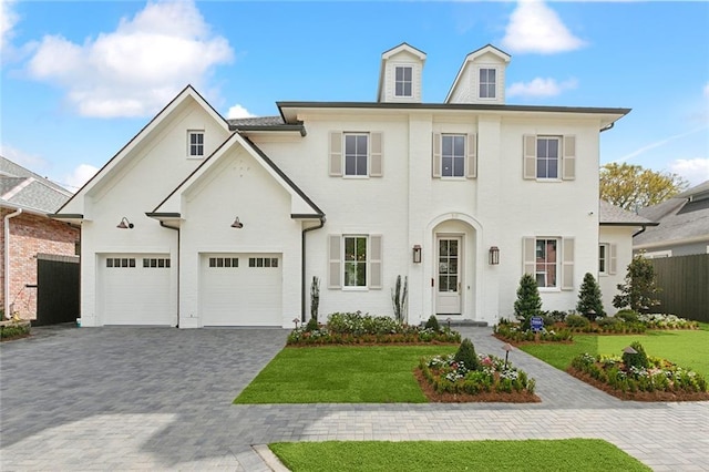 view of front facade featuring decorative driveway, a front lawn, and fence