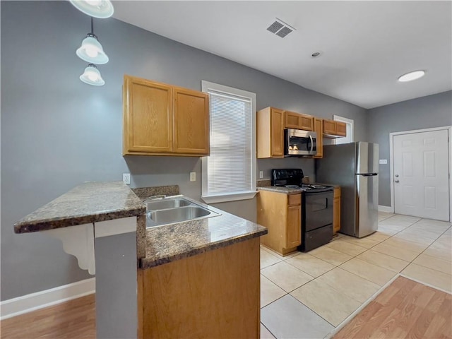 1824 Allen St, New Orleans, LA 70116 - kitchen featuring appliances with stainless steel finishes, a peninsula, pendant lighting, and healthy amount of natural light