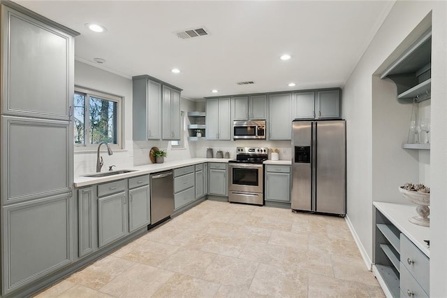 kitchen with tasteful backsplash, visible vents, gray cabinets, stainless steel appliances, and a sink