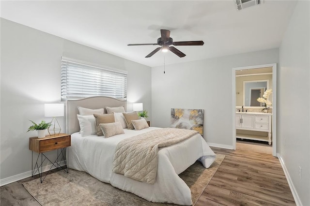 bedroom featuring visible vents, baseboards, and wood finished floors