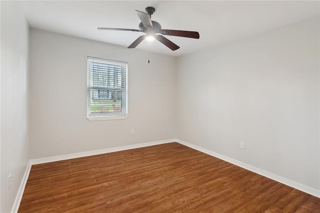 unfurnished room featuring a ceiling fan, wood finished floors, and baseboards