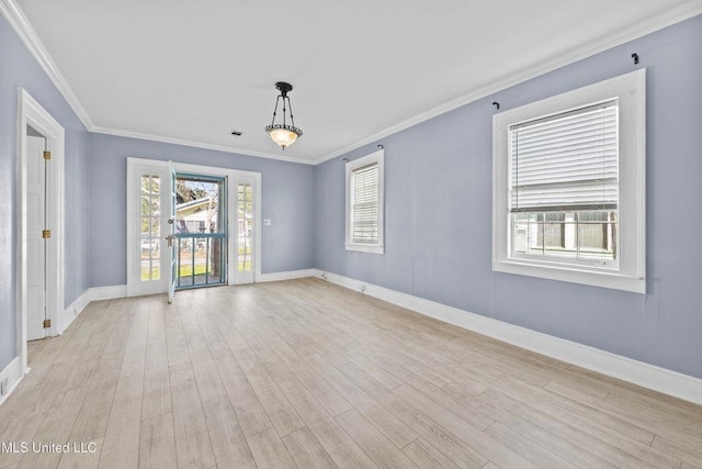 empty room featuring visible vents, baseboards, crown molding, and light wood finished floors