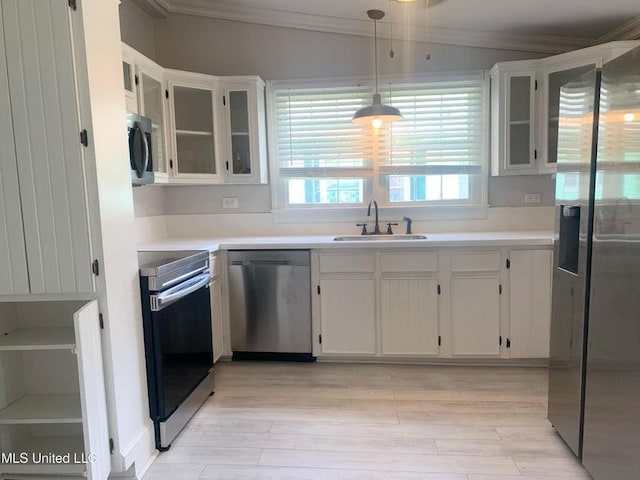 kitchen featuring a sink, stainless steel appliances, crown molding, and light countertops