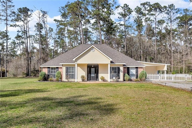 view of front of home with a front lawn, fence, roof with shingles, a carport, and driveway