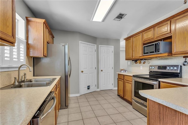 kitchen with visible vents, light countertops, brown cabinets, appliances with stainless steel finishes, and a sink