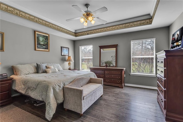 bedroom with multiple windows, a raised ceiling, ornamental molding, and dark wood-style flooring