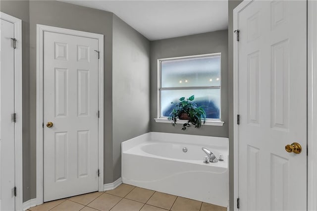 full bath featuring tile patterned floors, baseboards, and a bath