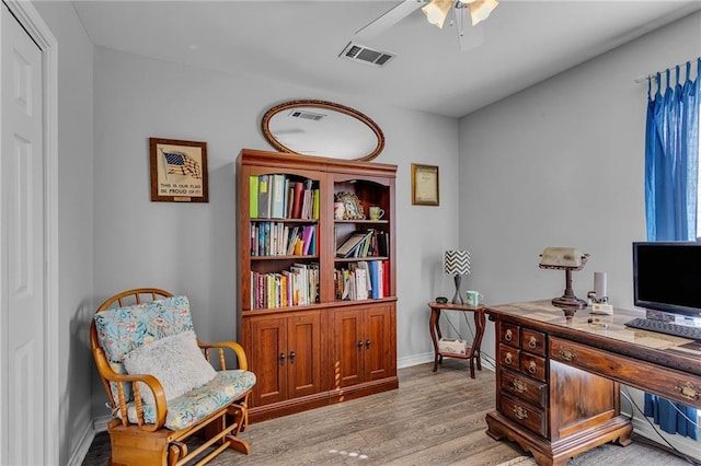 home office featuring visible vents, baseboards, light wood-style flooring, and a ceiling fan