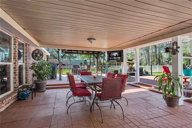 view of patio featuring outdoor dining space and fence