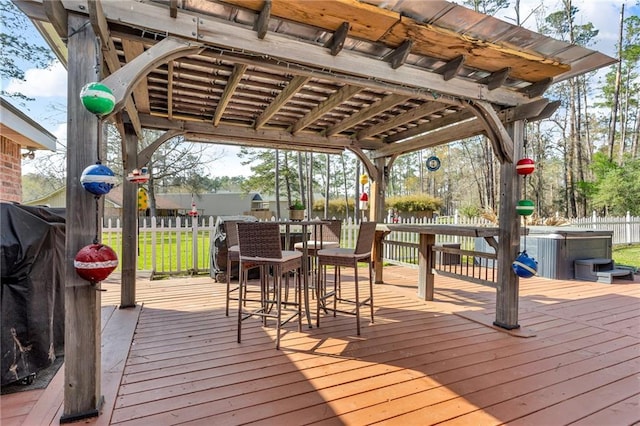 wooden deck with a hot tub, outdoor dining area, and fence