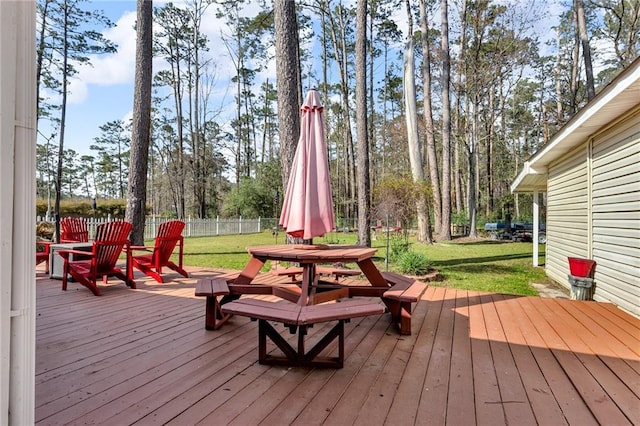 deck with a lawn, outdoor dining area, and fence