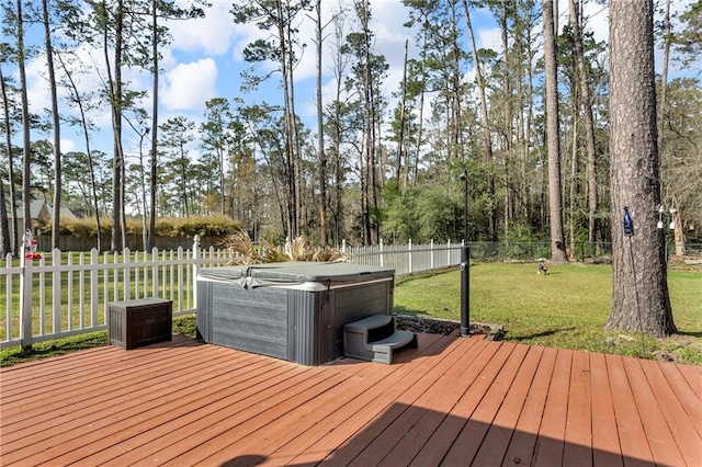 wooden deck featuring a fenced backyard, a hot tub, and a yard