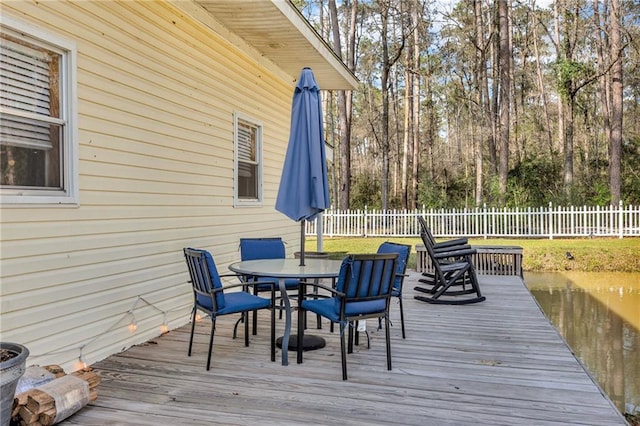 deck with outdoor dining space and fence