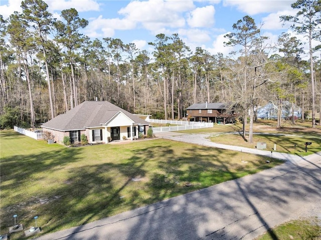 view of front of property featuring covered porch, a front yard, and fence