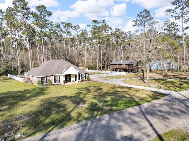 31501 River Pines Dr, Springfield, LA 70462 - view of front of house with a porch, fence, and a front lawn