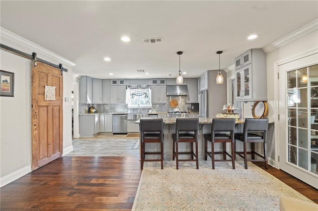 kitchen featuring visible vents, ventilation hood, gray cabinets, a peninsula, and stainless steel appliances