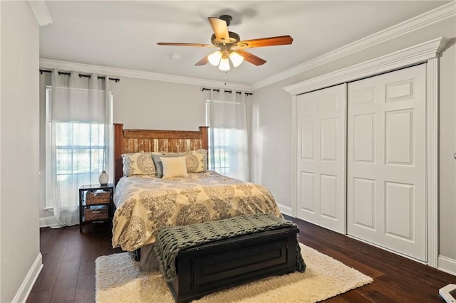 bedroom with crown molding, dark wood-style floors, a closet, and baseboards