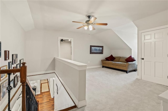 interior space with vaulted ceiling, an upstairs landing, light colored carpet, and baseboards