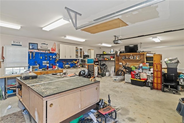 garage with a workshop area and a garage door opener