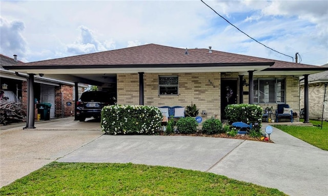 view of front of house featuring brick siding, driveway, a shingled roof, and an attached carport