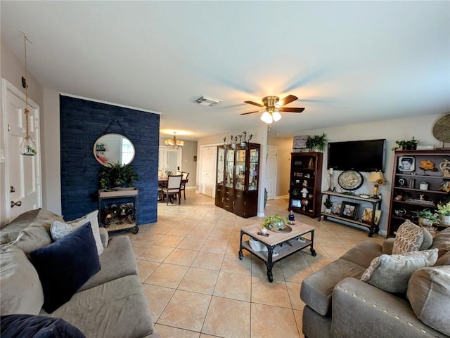 living area featuring light tile patterned flooring, visible vents, and ceiling fan with notable chandelier