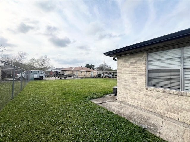view of yard with central AC unit and fence