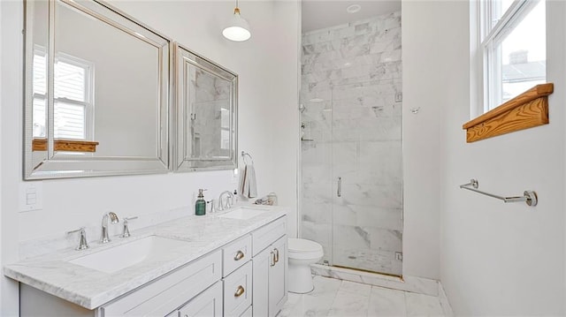 full bath with a sink, toilet, marble finish floor, and a stall shower