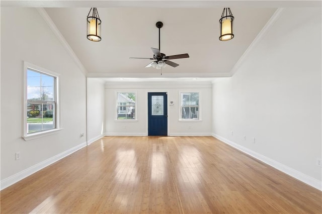 unfurnished living room with baseboards, ceiling fan, crown molding, and light wood finished floors