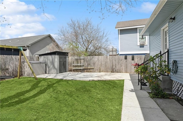 view of yard featuring a patio area, a fenced backyard, a storage unit, and an outdoor structure