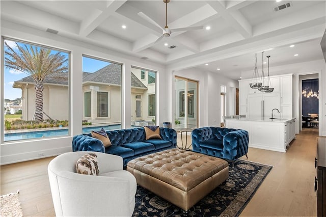 living room with visible vents, beam ceiling, light wood-style floors, and coffered ceiling