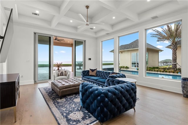 living area featuring visible vents, coffered ceiling, ceiling fan, a water view, and light wood-type flooring