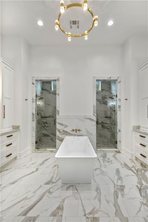 bathroom featuring a marble finish shower, recessed lighting, and an inviting chandelier