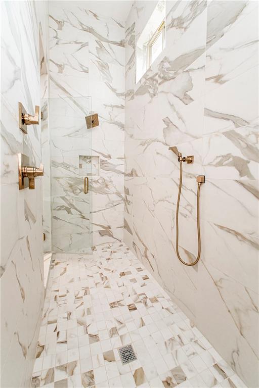 full bath featuring a marble finish shower