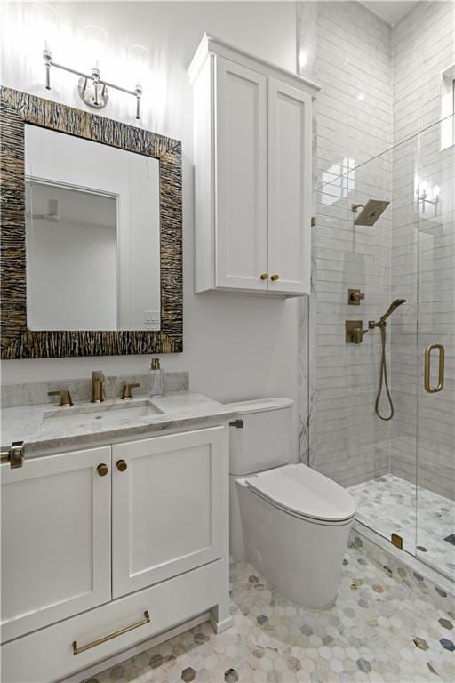 bathroom with vanity, toilet, and a shower stall