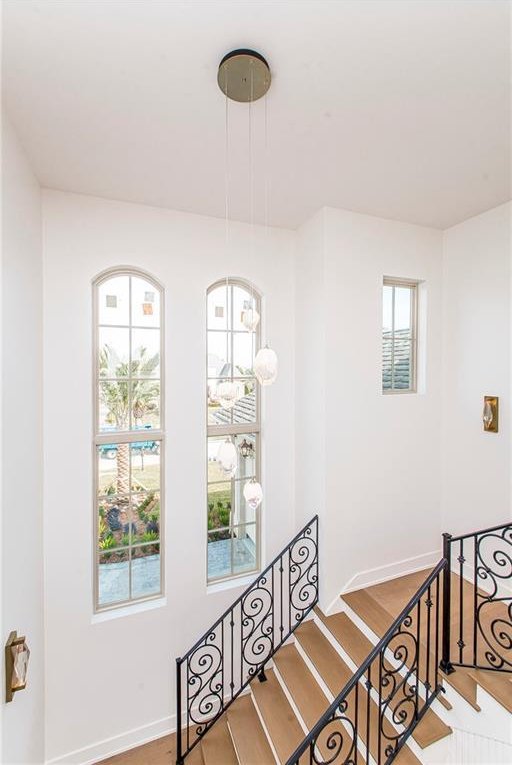 staircase with baseboards and wood finished floors