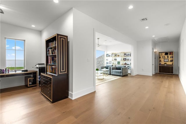 hallway with light wood finished floors, visible vents, recessed lighting, and attic access