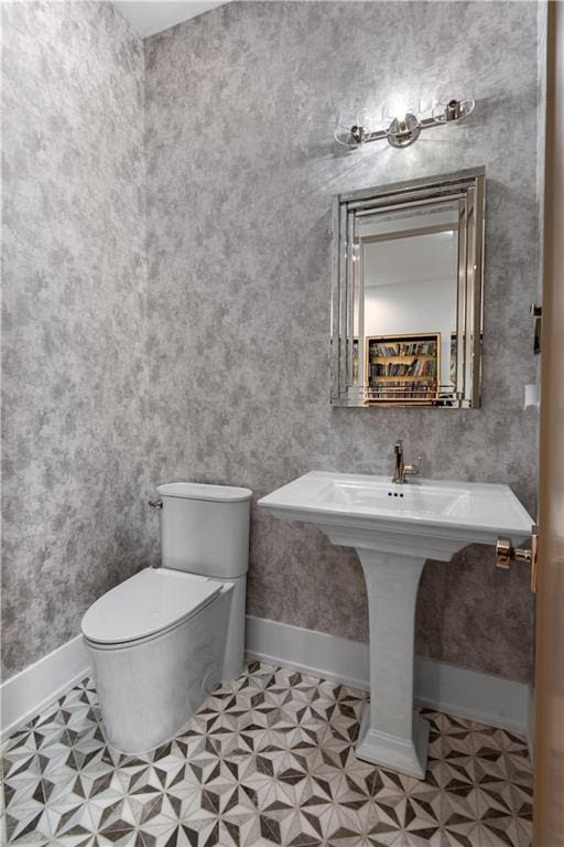 bathroom with tile patterned floors, toilet, and baseboards