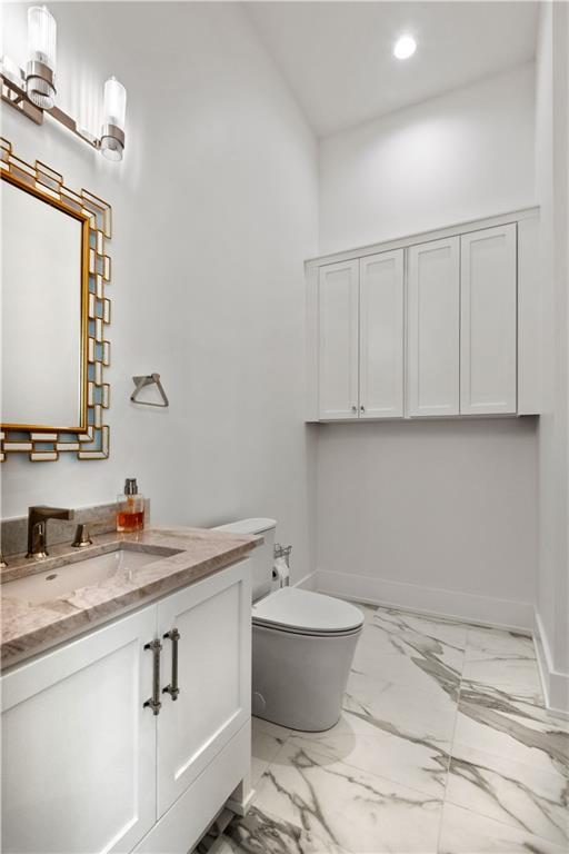 bathroom with vanity, baseboards, recessed lighting, toilet, and marble finish floor