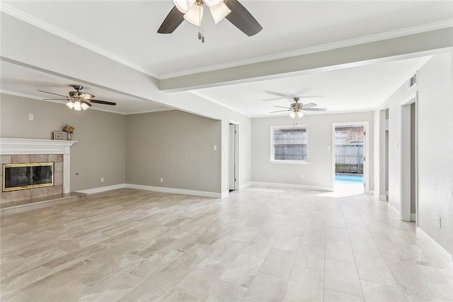 unfurnished living room with ceiling fan, a tile fireplace, and ornamental molding