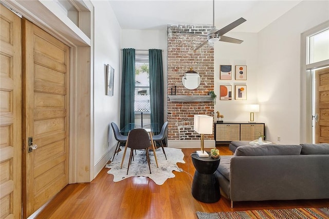 living room featuring a ceiling fan, vaulted ceiling, a wealth of natural light, and wood finished floors