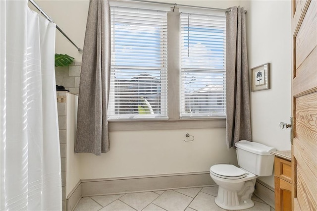 bathroom featuring baseboards, tile patterned floors, toilet, and curtained shower