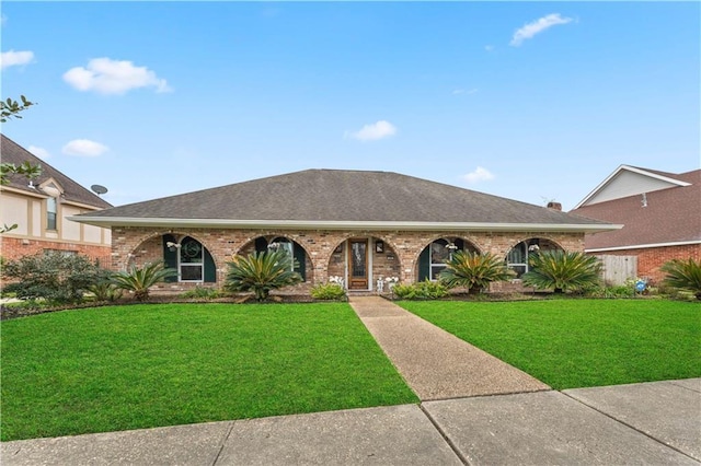 single story home with brick siding, a front yard, and roof with shingles