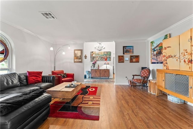 living room featuring crown molding, wood finished floors, and visible vents