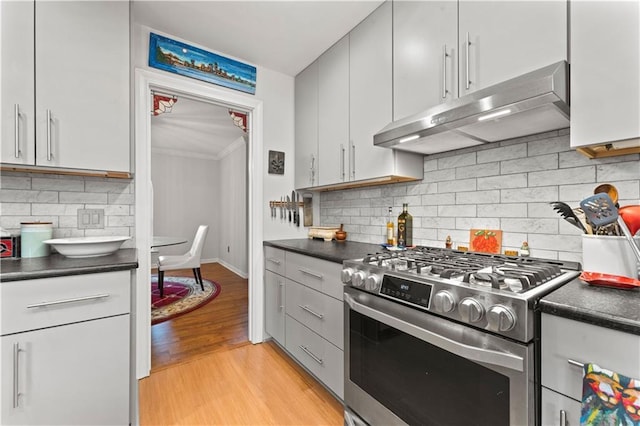 kitchen featuring dark countertops, gas stove, and under cabinet range hood