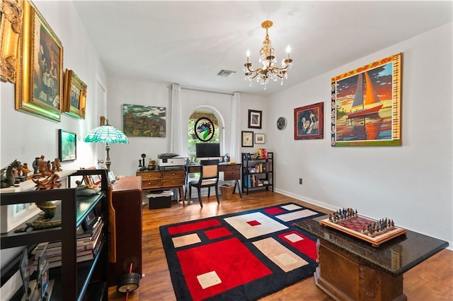 home office with visible vents, baseboards, a notable chandelier, and wood finished floors