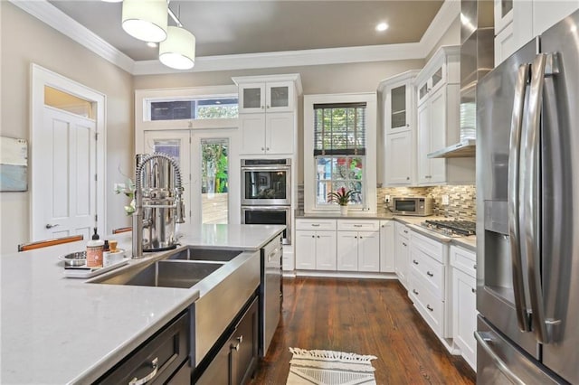 kitchen featuring tasteful backsplash, white cabinets, stainless steel appliances, and crown molding