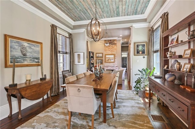 dining room with crown molding, wood finished floors, baseboards, and a chandelier