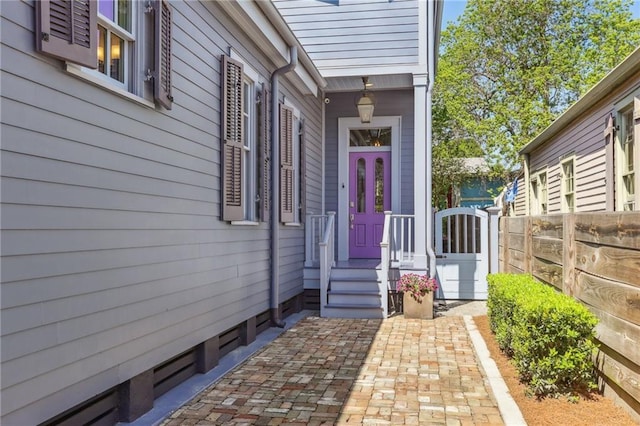 view of exterior entry with fence